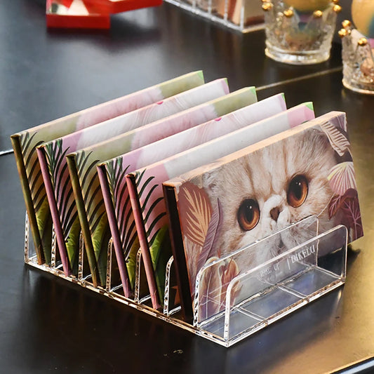 Acrylic card holder with floral and cat-themed cards on a dark surface