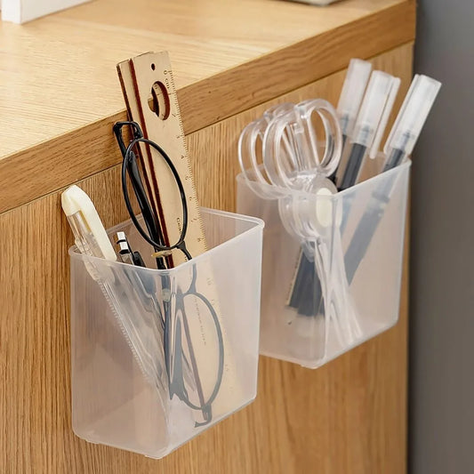 Clear wall-mounted organizers with stationery items on a wooden surface