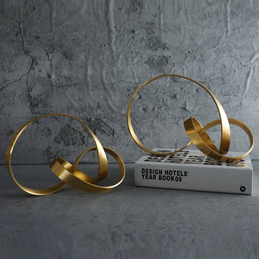 Elevate your space with the Gold Hollow Twist Art Ornament, a stunning modern metal decor piece perfect for living rooms and desks.
